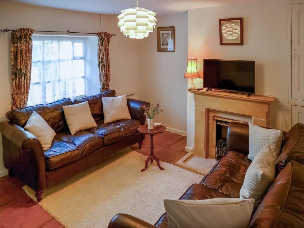 a living room with a couch and a fireplace at Pam's Cottage in Cheltenham
