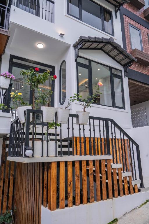 a house with potted plants on a balcony at Mộc in Ấp Ða Lợi