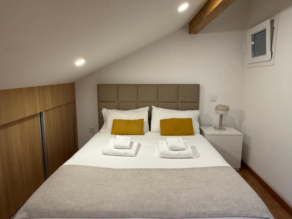 a bedroom with a large white bed with two pillows at Porta 4 City Flat in Vila Real