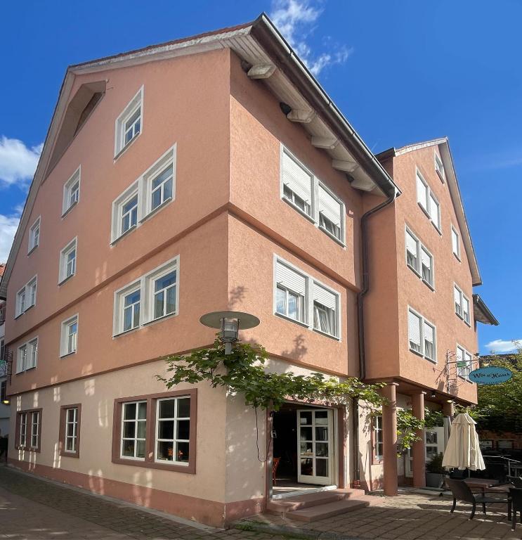 ein braunes Gebäude mit weißen Fenstern an einer Straße in der Unterkunft Steingarten Hotel in Wertheim