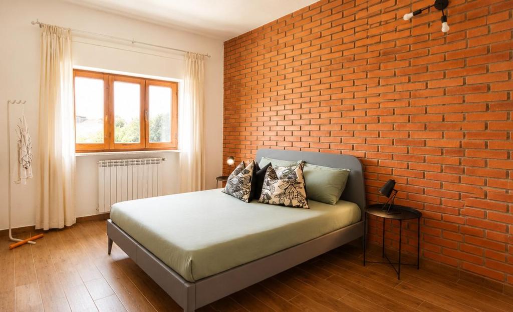 a bedroom with a bed against a brick wall at Villa nel centro di Palau in Palau