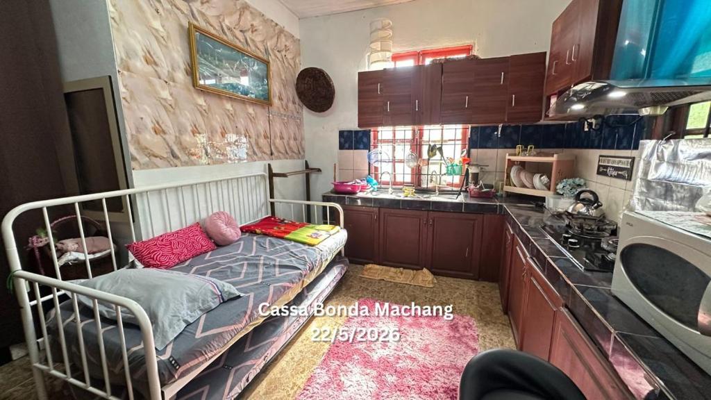 a kitchen with a crib in the middle of a room at Cassa Bonda Single Studio in Kampong Bakat