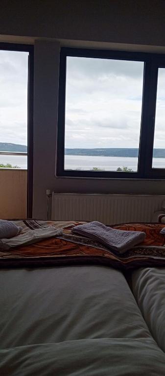 a bed in a room with two windows at Ayışık Otel in Hamidiye