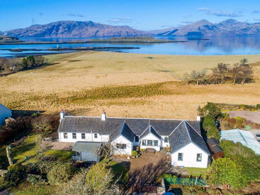 an aerial view of a house with a lake and mountains at Ardtur Croft in Appin