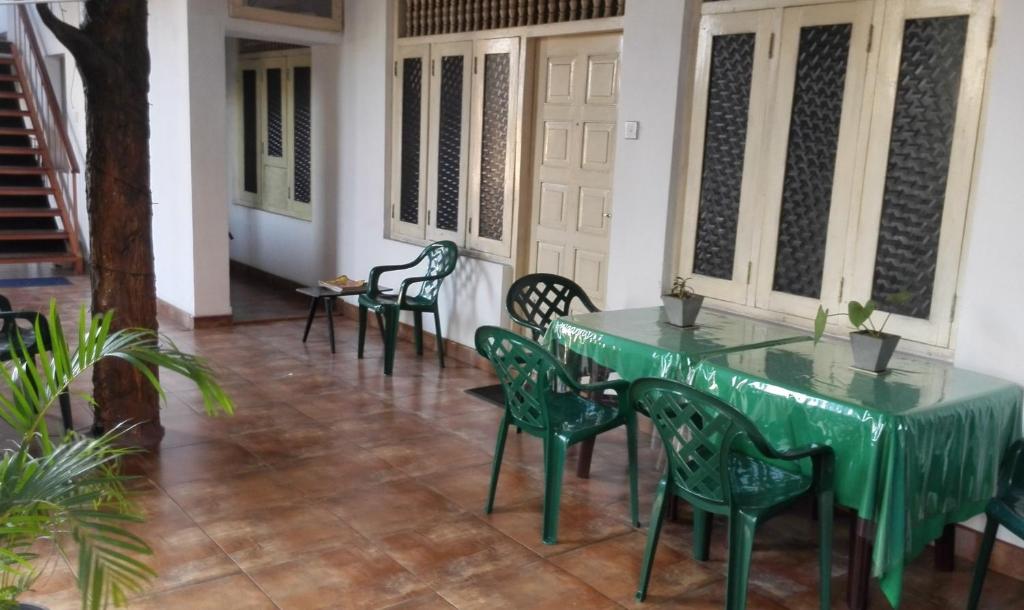 a green table and chairs in a room at Hotel 100 in Dehiwala