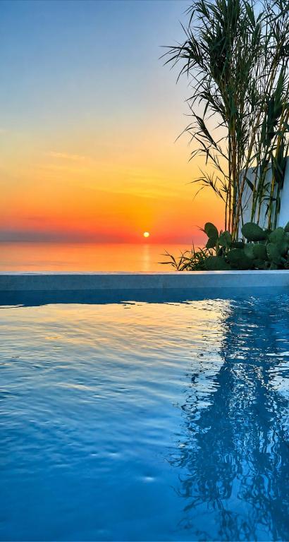 a swimming pool with a sunset in the background at Martynou View in Pyrgos