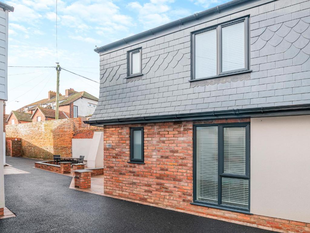 a brick house with windows and a driveway at Martin - Uk48161 in Filey