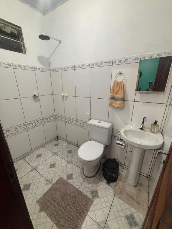 a bathroom with a toilet and a sink at Casapalmares in Parintins