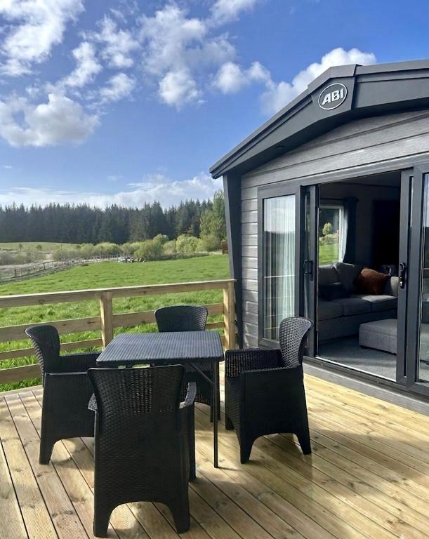 a patio with a table and chairs and a couch at Barnharrow Holiday Park in Newton Stewart