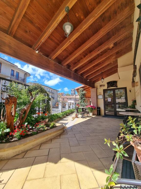 an outdoor patio with a wooden roof and flowers at Hotel Belvedere Tonara in Tonara