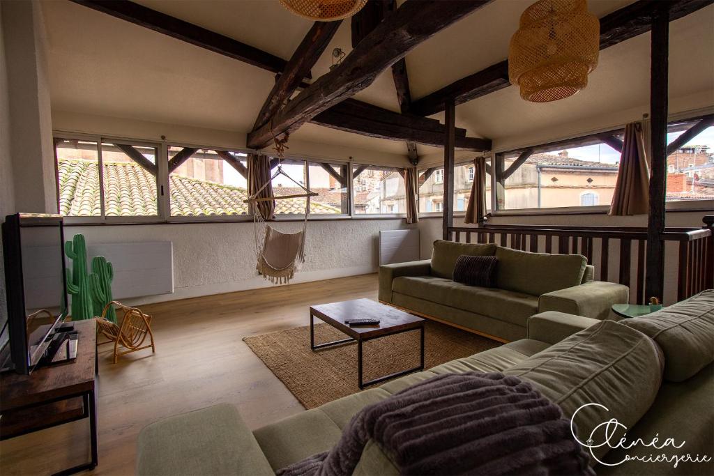 a living room with a couch and a table at Sous les toits de Sainte-Cécile in Albi