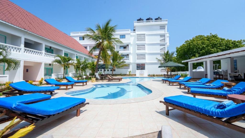 a pool at the hotel with blue lounge chairs at The Safiya Hotel, Diani Beach, "Formely Diani Palm Resort" in Diani Beach