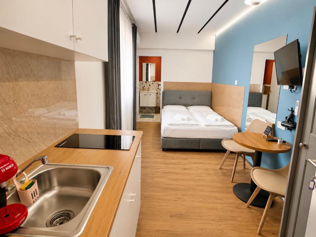 a kitchen with a sink and a room with a bed at Modern Studio 7 private Kitchenette and Bathroom in Limassol