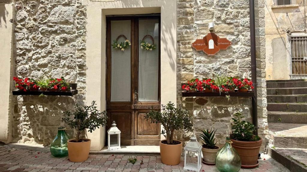 a front door of a house with potted plants at Nel Borgo di San Francesco - Ospitalità Diffusa - Relax tra Roccaraso e Costa dei Trabocchi in Villa Santa Maria