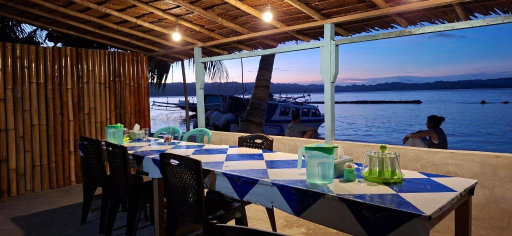 a blue and white table with chairs and a view of the water at NATA homestay in Banggai