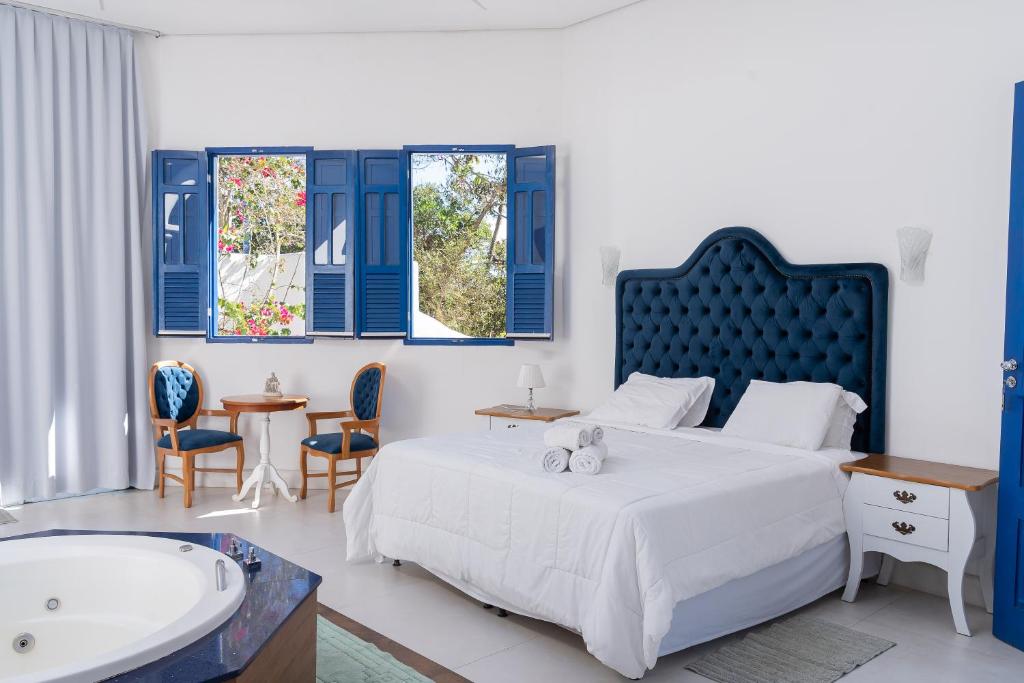 a bedroom with a large bed and a bath tub at Ilhas Gregas Chalets in Lavras Novas