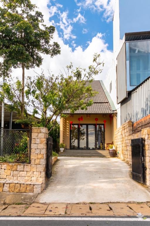 a building with a stone wall and a driveway at DaLaHa City in Da Lat