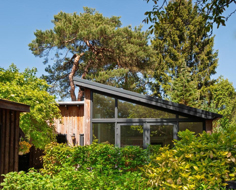 a glass house with a black roof at Studio Bosrijk Bilthoven in Bilthoven