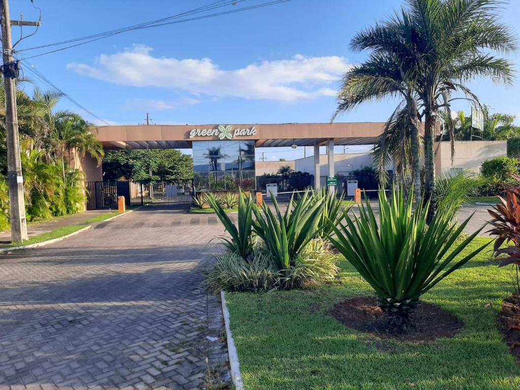a gas station with palm trees in front of it at Apto 2Q com Area de Lazer e Piscina in São Gonçalo do Amarante