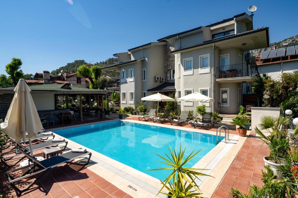 a pool at a hotel with chairs and umbrellas at No 14 HOTEL GÖCEK in Göcek