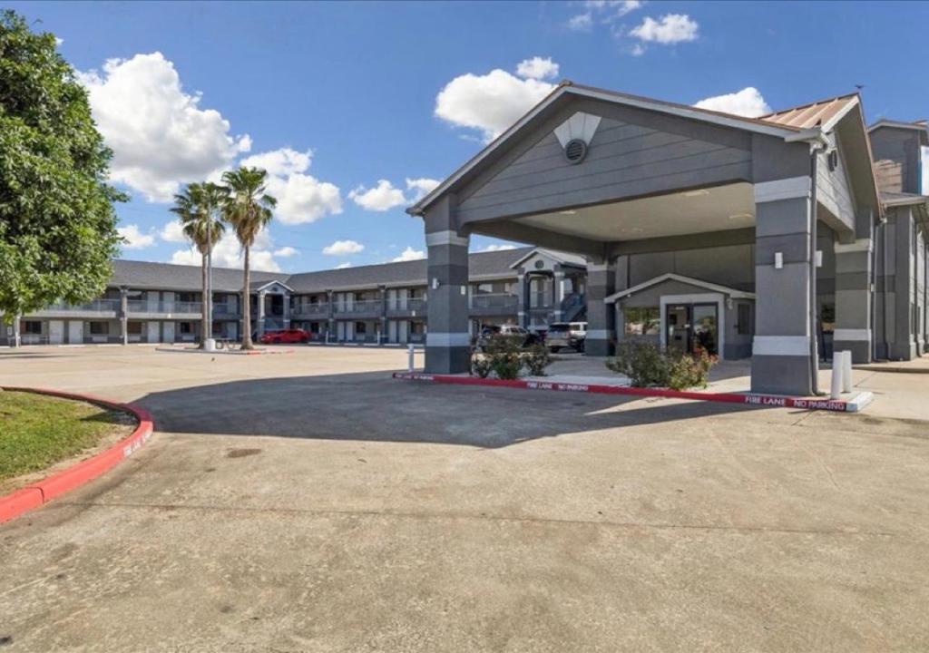 a large building with palm trees in front of it at Hotel Blue Baytown, Texas in Baytown