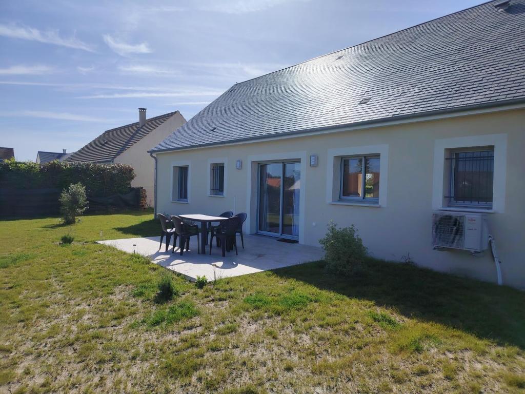 a white house with a table and chairs in the yard at Sologne Escape in Tour-en-Sologne