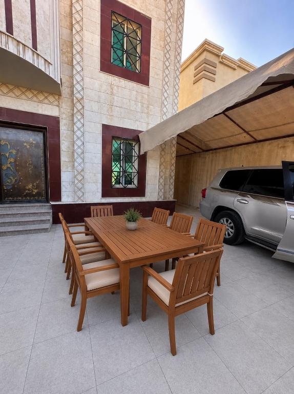 a wooden table and chairs on a patio at فلة الضيافة المميزة Dhiafa Villa in Dammam