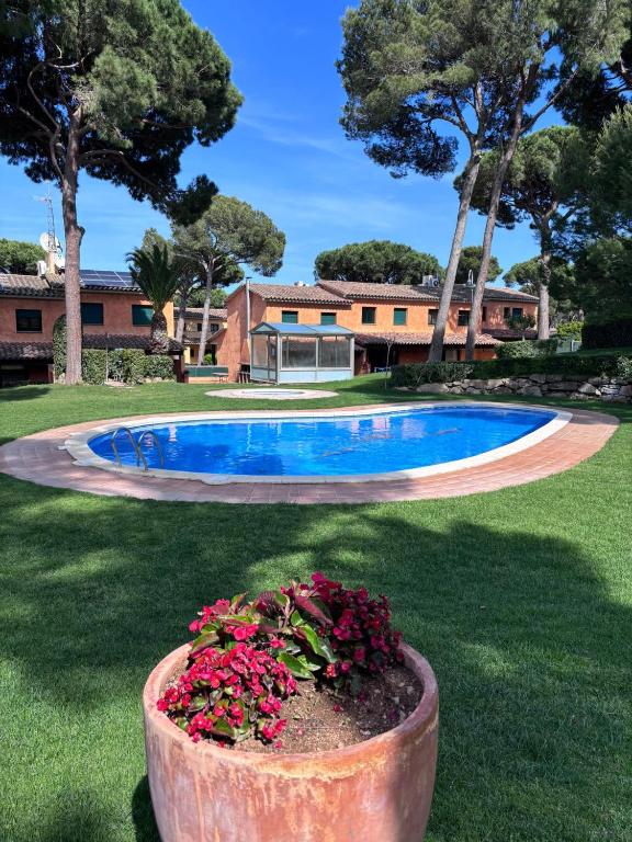 a house with a swimming pool and flowers in a yard at Casas Golf Relax in Pals