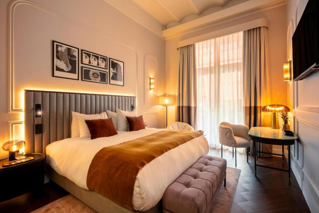 a hotel room with a large bed and a chair at The Manor Amsterdam in Amsterdam