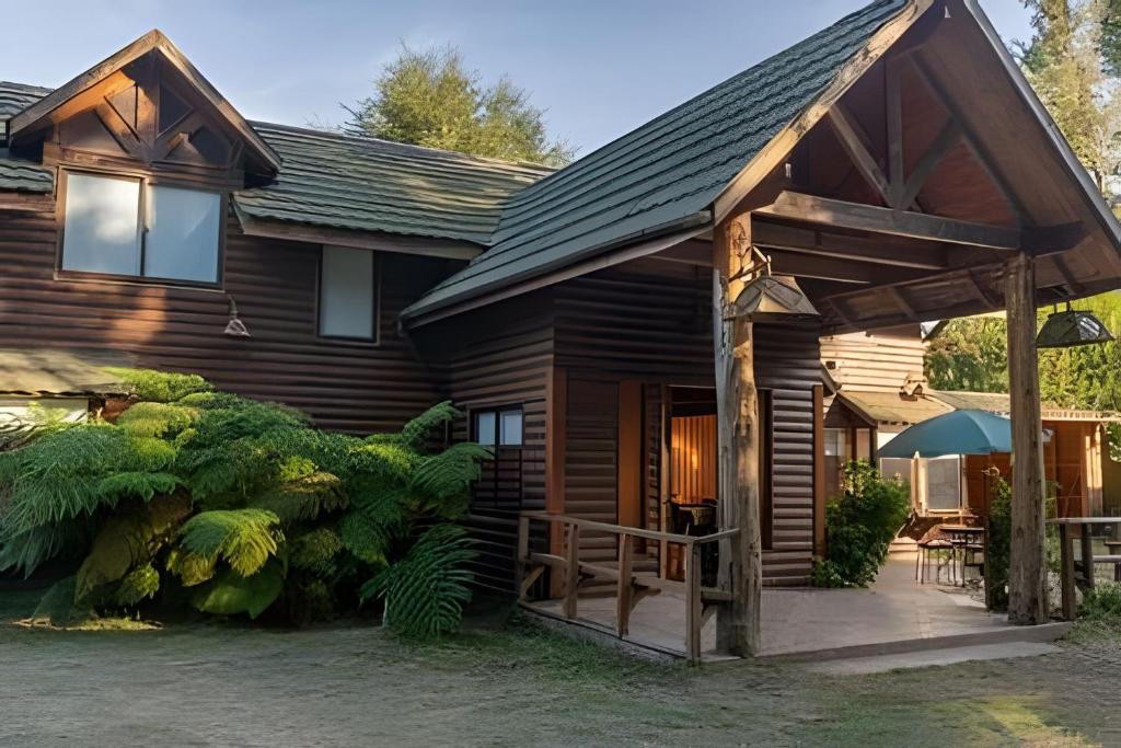 eine Blockhütte mit Veranda und Terrasse in der Unterkunft Impresionante casa + Starlink | Bosque y estufa in Pucón