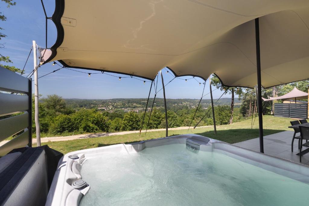 a hot tub in a tent with a view at Le Pech Eternel-Lodge Spa Tilleuls in Sarlat-la-Canéda