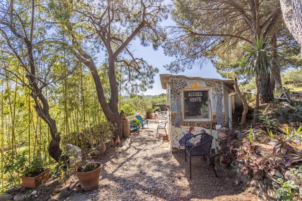 a kiosk in a garden with trees and plants at Gite Insolite Mas Boutet in Argelès-sur-Mer