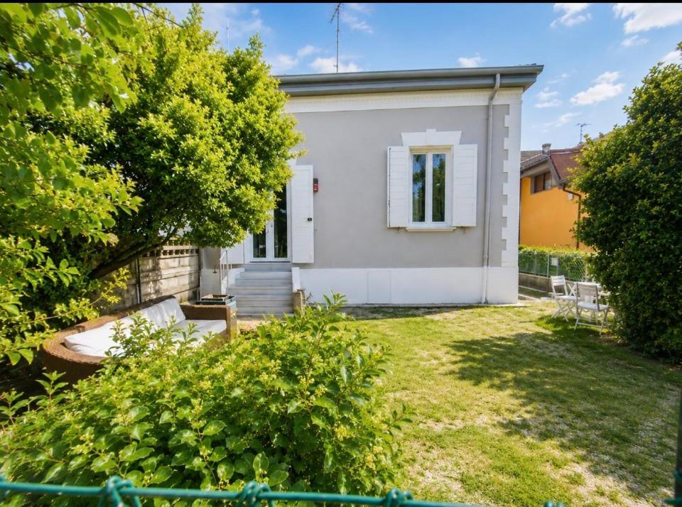 a white house with a window and a yard at Casa Elisa 10 B in Bellaria-Igea Marina