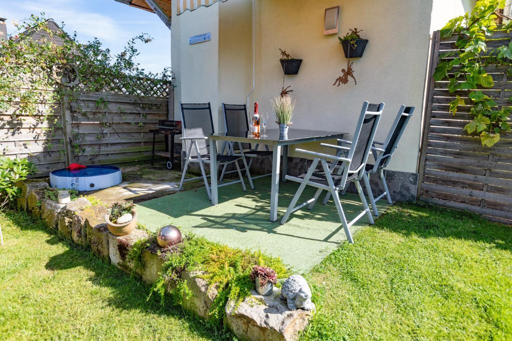 a patio with a table and chairs in a yard at Ferienwohnung Am Feldrain in Hannoversch Münden