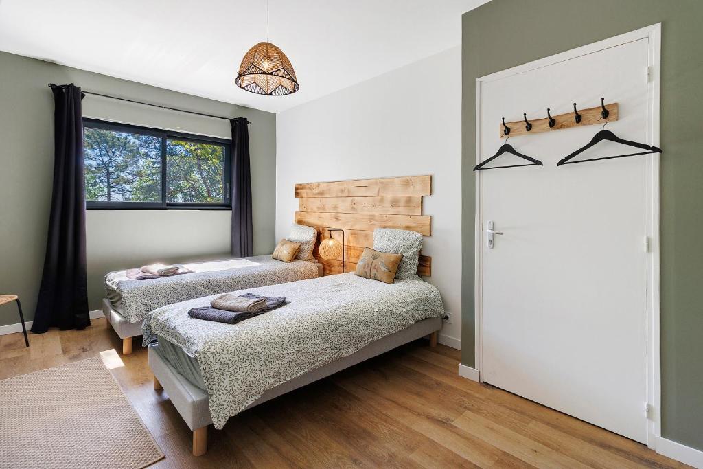 a bedroom with two beds and a window at Le Pech Eternel - La Truffière in Sarlat-la-Canéda