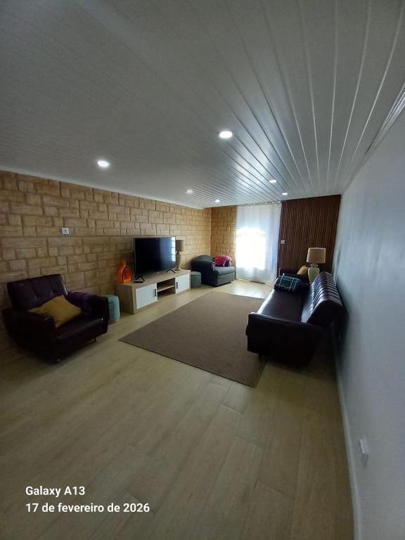 a living room with couches and a flat screen tv at Apartamento do Chico in Terra Chã