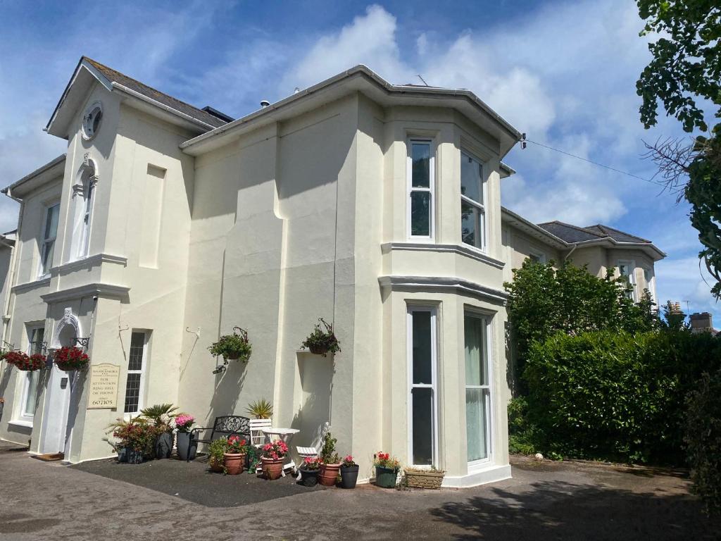 a white house with potted plants in front of it at Apartment 2 in Torquay