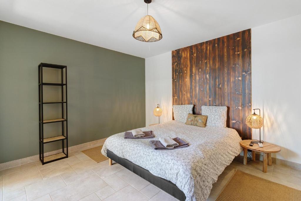 a bedroom with a large bed with a wooden wall at Le Pech Eternel - La Sablière in Sarlat-la-Canéda
