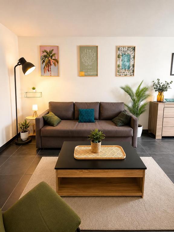 a living room with a couch and a coffee table at Charmant T2 Bordeaux Proche tram & centre-ville in Bruges