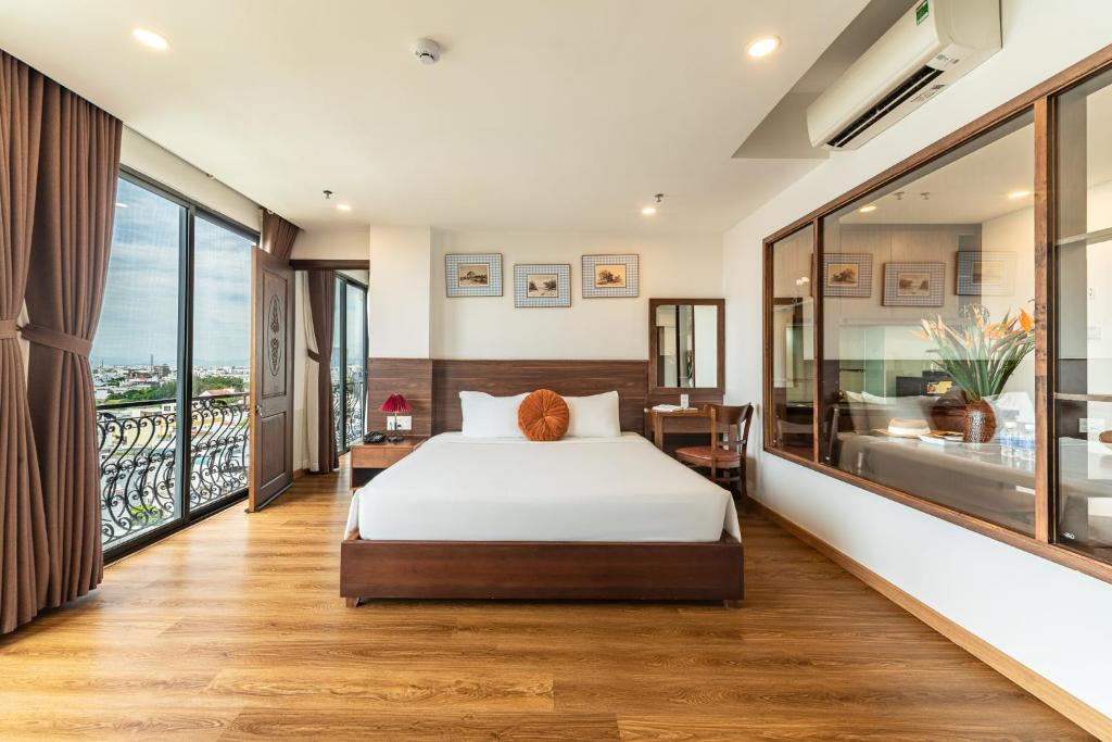 a bedroom with a bed and a balcony at Dian Hotel & Apartment in Danang