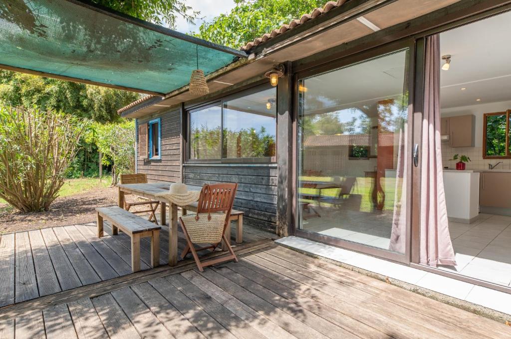 a patio with a table and chairs and sliding glass doors at Case di Mare Chalet Bignone in Cervione