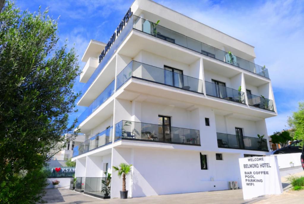 a white building with balconies on it at Belmond Hotel in Ksamil