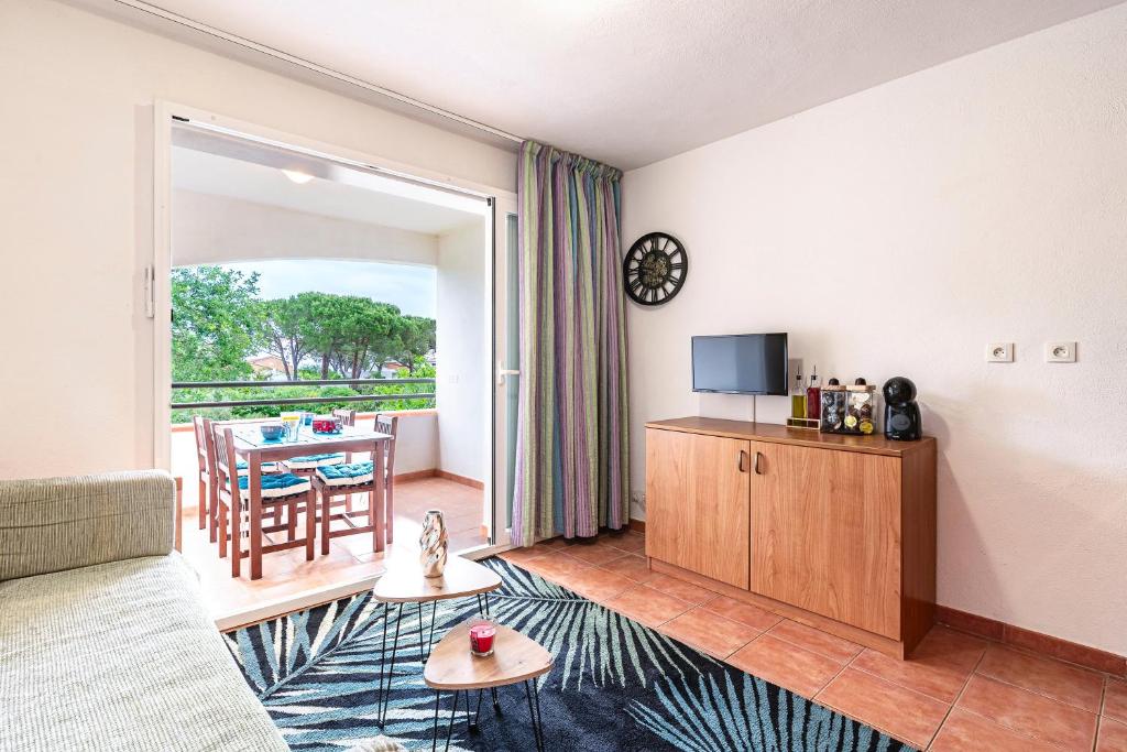 a living room with a couch and a television at L'Escapade Corse - À 80 mètres de la plage in San-Nicolao
