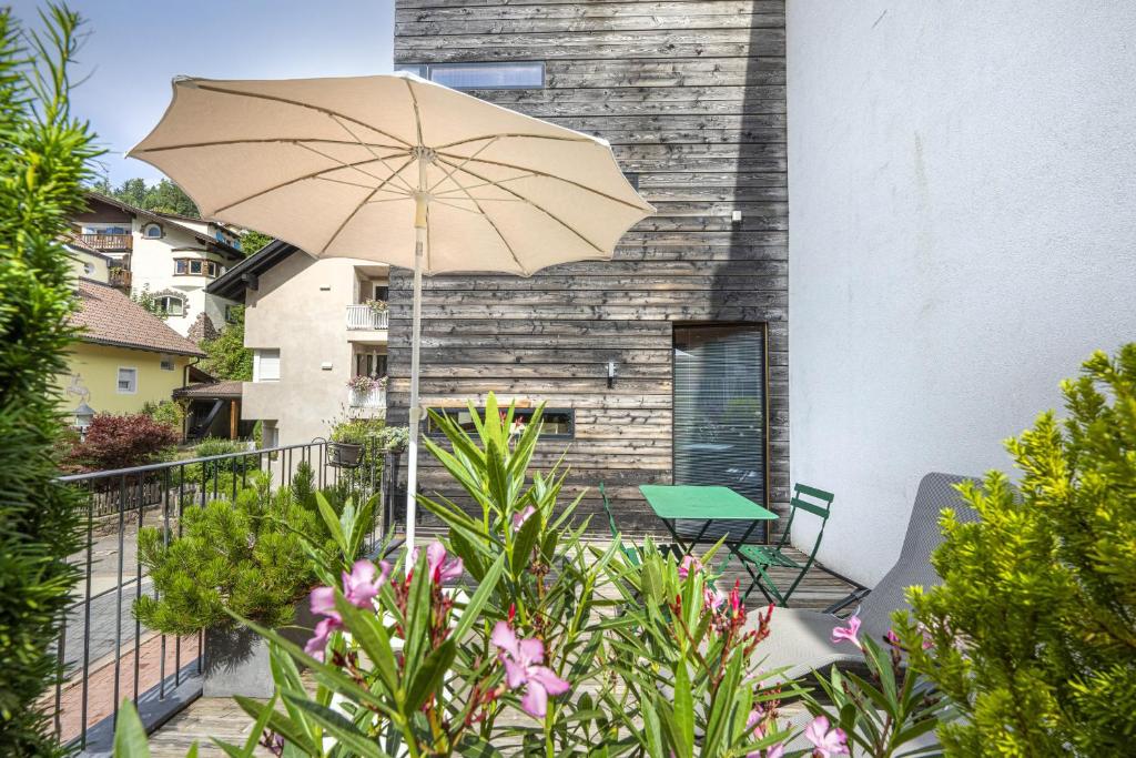 a patio with a table and an umbrella at Design Lodge The Cube in Ortisei