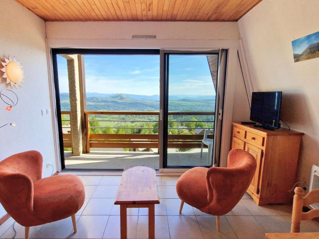 a living room with two chairs and a large window at Grand appartement pour 12 pers. avec balcon sud, WIFI, parking et proche pistes – St Michel de Chaillol - FR-1-393-11 in Saint-Michel-de-Chaillol
