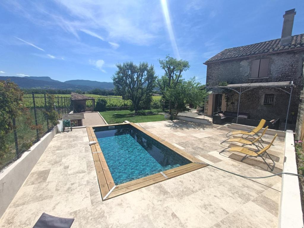 a swimming pool on a patio with a house at Gîte - La Sabletine in Sablet
