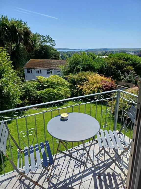 a table and two chairs on a balcony at Sea Gem - large holiday cottage in Tenby with private parking in Tenby