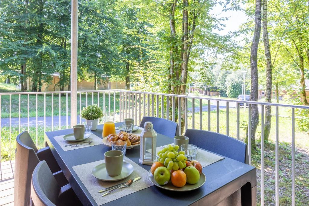 a table with fruit on it on a balcony at Les Charmes C10 - Le Val Joly in Eppe-Sauvage
