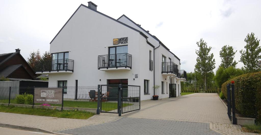 a white building with balconies on the side of it at Morski Piasek in Grzybowo