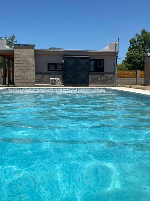 a swimming pool in front of a house at Cabañas Los Robles Premium in Villa Quillinzo